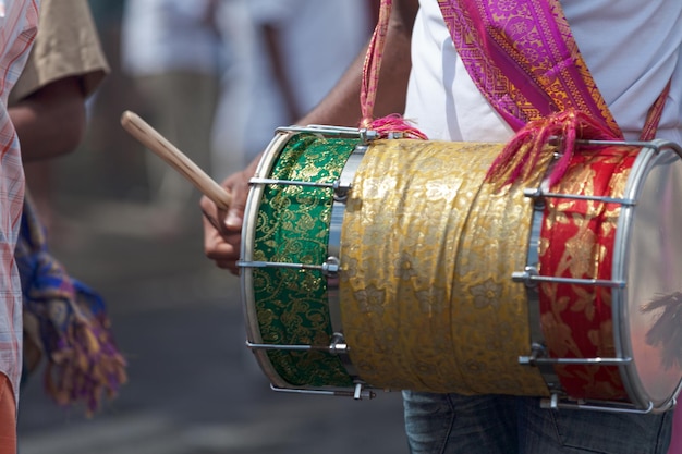 Percusionista tocando con un dholak durante el carnaval de Grand Boucan