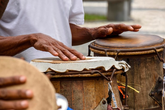 Percussionista tocando atabaque durante la presentación de la capoeira afrobrasileña en Pelourinho en Salvador