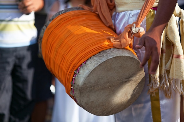 Percussionista tocando com um dhol durante o carnaval de Grand Boucan