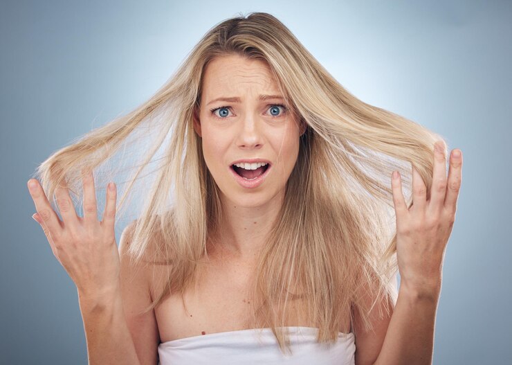 Foto perda de cabelo de retrato de rosto e mulher chocada no estúdio isolado em um fundo cinza beleza surpreendida e modelo feminino triste com raiva ou frustrada com danos capilares pontas duplas ou penteado bagunçado