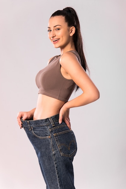 perder peso e o conceito de dieta. Mulher slim fit mostrando resultados após fitness e exercícios