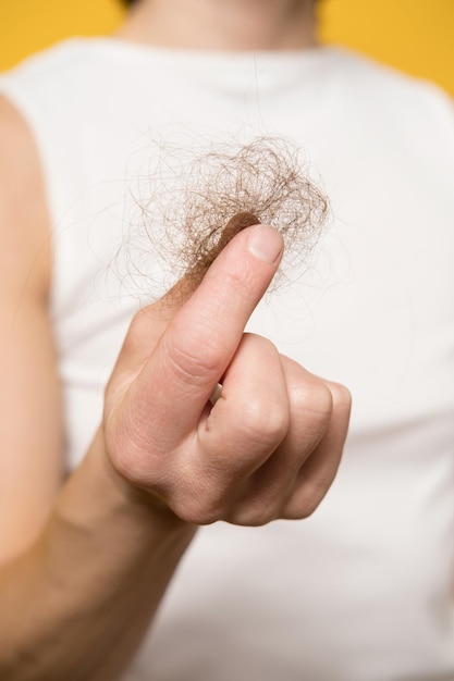 Foto pérdida de cabello mano femenina sostiene un moño de cabello