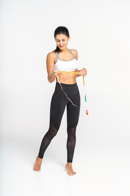 Pérdida de peso cuerpo delgado concepto saludable Chica fitness midiendo su cintura con cinta métrica