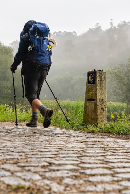 Peregrino caminando en el camino de Santiago (Santiago) en un día brumoso en Galicia