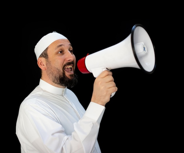 Peregrino musulmán con ropa tradicional blanca, diciendo mensaje en megáfono. foto de alta calidad
