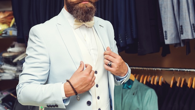 Perfeito até o último detalhe. Empresário moderno. Foto de moda de um homem bonito em um elegante terno clássico. Beleza masculina, moda. Homem bonito barbudo e brutal em terno azul brilhante