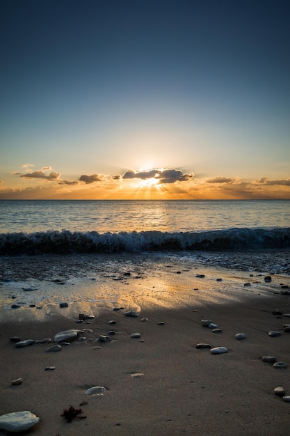 Perfekter Blick auf die flammende Meereslandschaft von einem Strand bei Sonnenuntergang