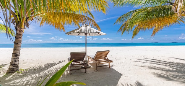 Perfekter tropischer Strand Sommerlandschaft mit Stühlen und Sonnenschirm auf weißem Sand in der Nähe des blauen Meereshimmels