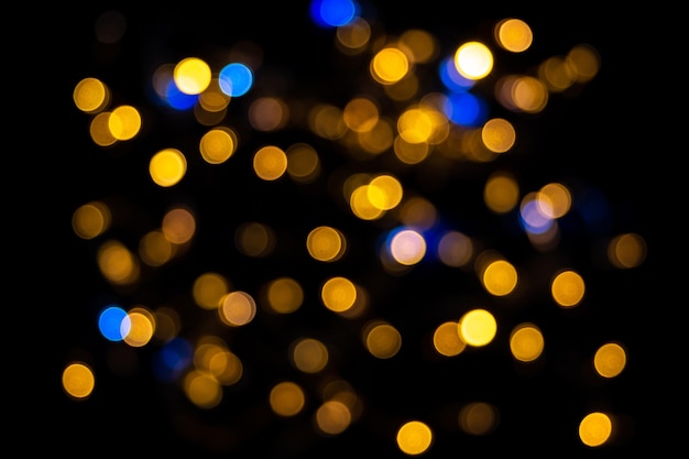 Perfektes Bokeh für einen festlichen Neujahrs- und Weihnachtshintergrund. Defokussierte abstrakte gelbe und blaue Lichtkreise. Bokeh wird über den gesamten Rahmen verteilt