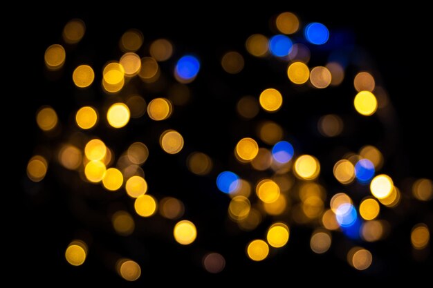 Perfektes Bokeh für einen festlichen Neujahrs- und Weihnachtshintergrund. Defokussierte abstrakte gelbe und blaue Lichtkreise. Bokeh wird über den gesamten Rahmen verteilt