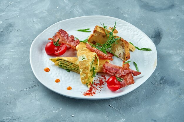 Perfektes Frühstück - Rührei mit Spinat, Speck und frischem Brot auf einem weißen Teller. Leckeres Omelett