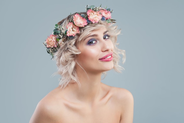 Perfektes Modell im Blumenkronenporträt Schöne Frau mit kurzen blonden Locken und Make-up