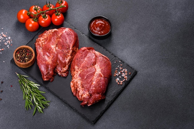 Perfektes rohes Rib-Eye-Beefsteak auf schwarzem Holzhintergrund, Nahaufnahme