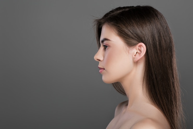 Perfil de una bella joven de piel perfecta y maquillaje natural. copia espacio