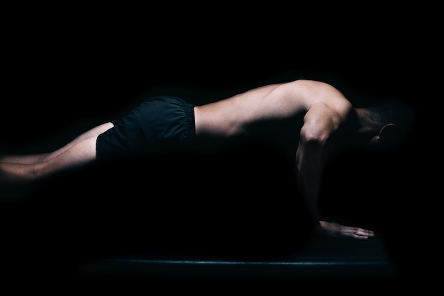 Perfil de un hombre fitness haciendo flexiones