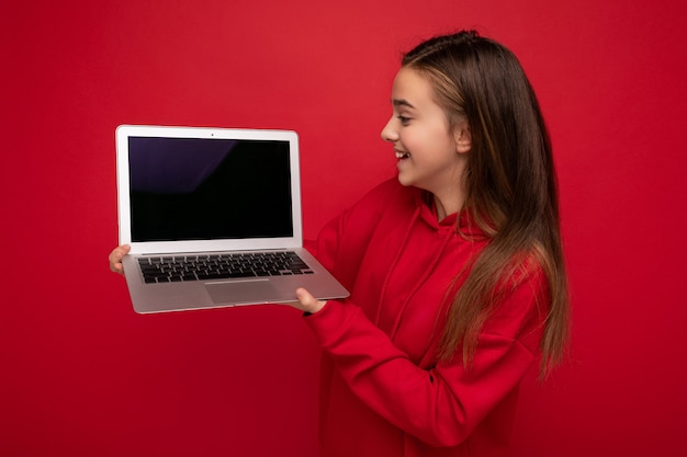 Perfil lateral hermosa niña feliz con pelo largo con sudadera con capucha roja