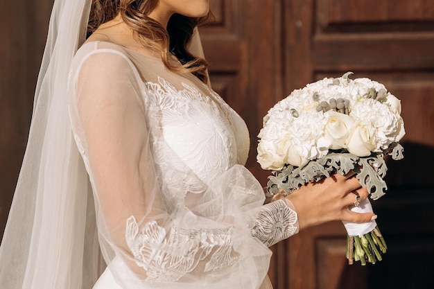 Perfil de una novia sosteniendo un ramo blanco de boda de lujo Detalles de la boda