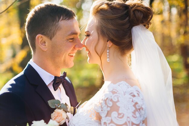 Perfil de recién casados sonriendo en el parque de cerca