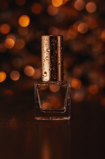 Foto perfume con fondo dorado borroso