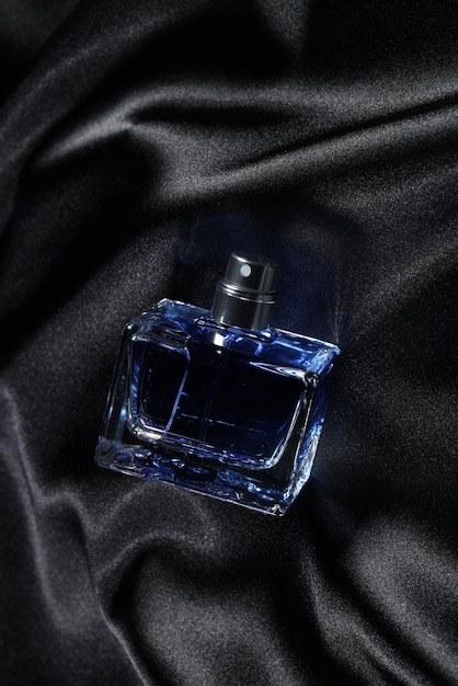 Perfumes de luxo para homens em garrafa em tecido de cetim preto acima da vista