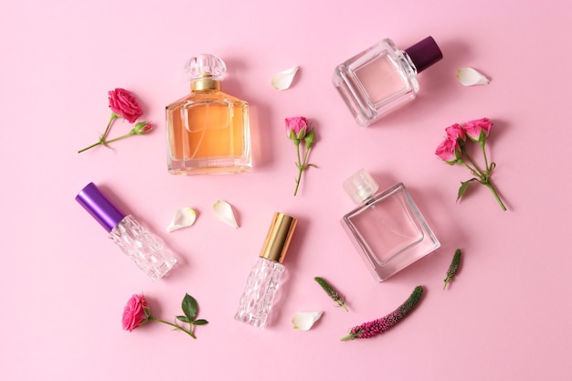Perfumes e flores em fundo colorido