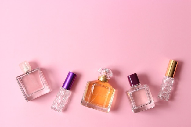 Perfumes e flores em fundo colorido