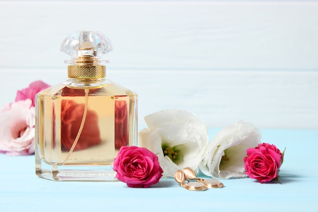 Perfumes e flores em fundo colorido