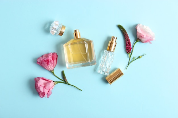 Perfumes e flores em fundo colorido