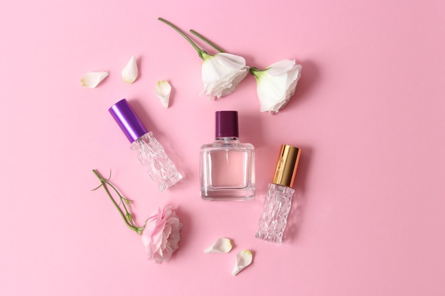 Perfumes y flores sobre un fondo de color