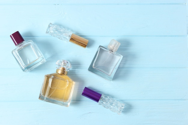 Foto perfumes y flores sobre un fondo de color