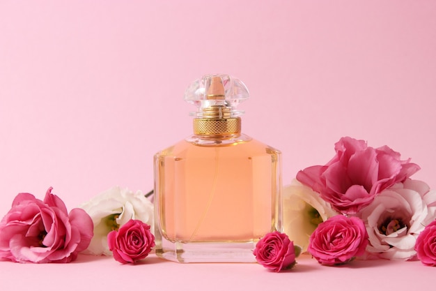 Perfumes y flores sobre un fondo de color