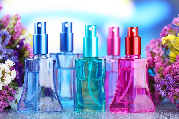 Perfumes de mujer en hermosas botellas y flores.