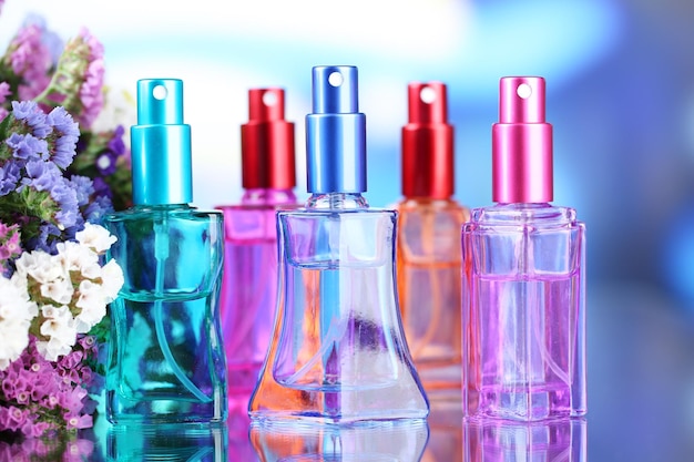 Perfumes de mujer en hermosas botellas y flores.