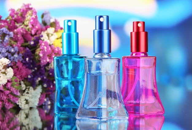 Foto perfumes de mujer en hermosas botellas y flores.