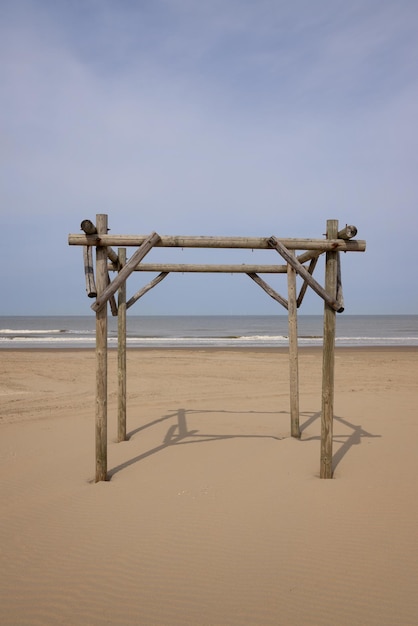 Pergola de madeira solitária na praia de areia