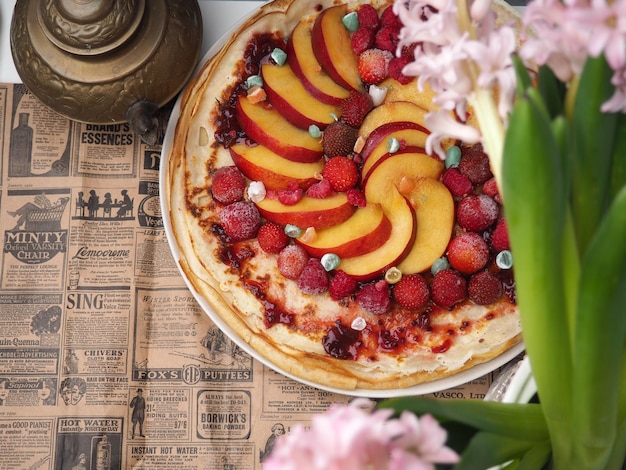 Un periódico con un ramo de flores y una pizza.