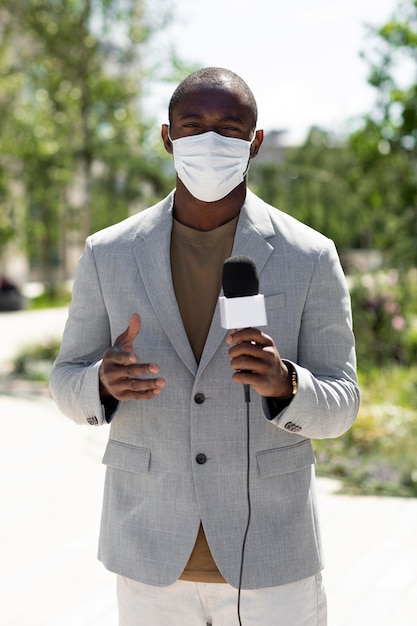 Periodista masculino con una máscara médica