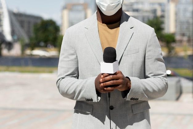 Periodista masculino con una máscara médica