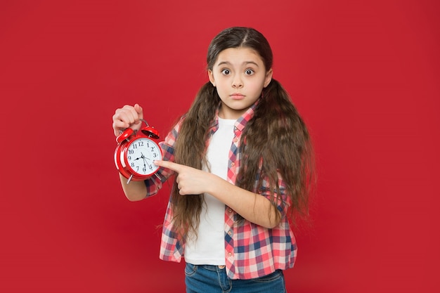 Período del día de sueño. horario para niños. despertar. niño adolescente que muestra la hora en el reloj. chica apuntando con el dedo. niño llegando tarde. Buenos días. gestión del tiempo. reloj mecánico retro.