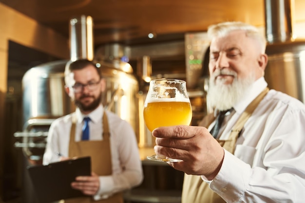 Foto peritos examinando cerveja na fábrica