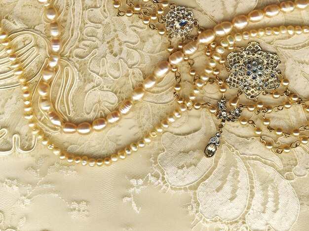 Perlas elegantes y broches antiguos en encaje delicado