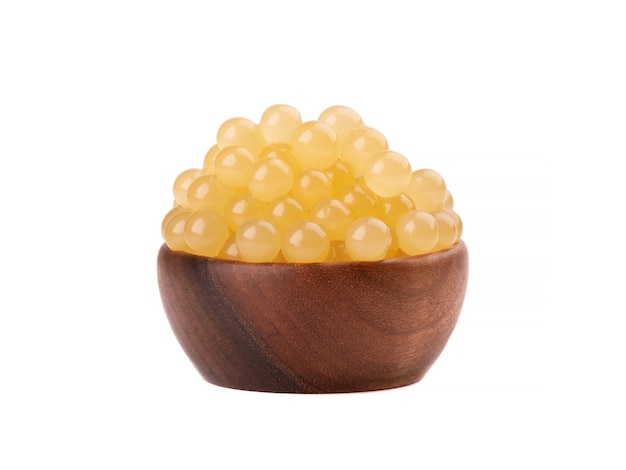 Perlas de tapioca amarillas para té de burbujas aisladas Perlas de tapioca en un tazón de madera.