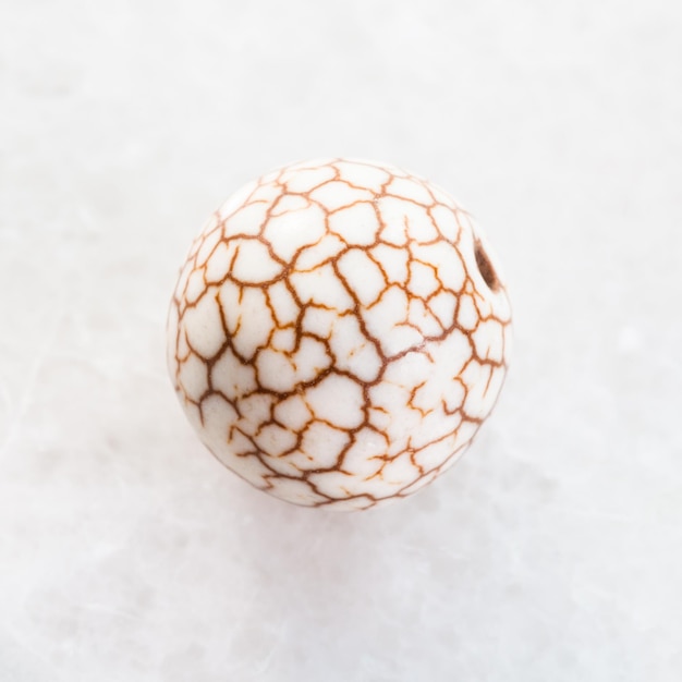 Perle aus gebrochenem Cacholong-Edelstein auf Weiß