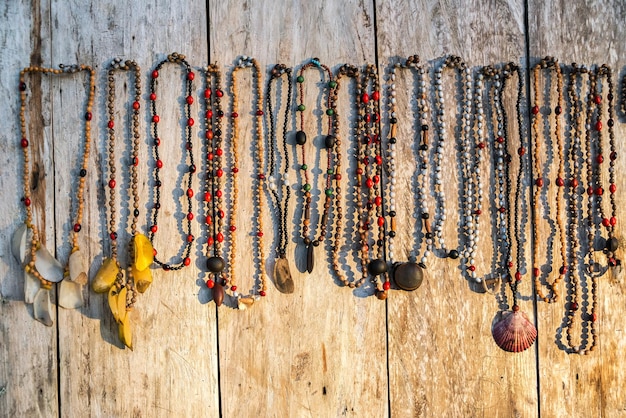 Foto perlenhalsketten, die auf holz hängen und auf dem markt zu verkaufen sind