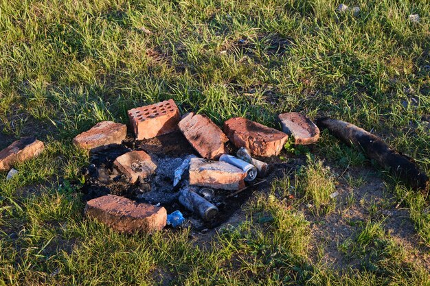 Permanece fogueira extinta e poluição ambiental de lixo abandonado