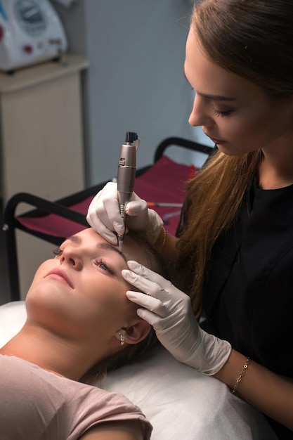 Permanentes Augenbrauen Make-up. Kosmetikerin beim Tätowieren von Augenbrauen.