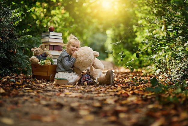 Permítales pensar con más libertad Fotografía de una niña leyendo a sus juguetes mientras está en el bosque