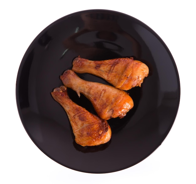 Perna de frango assada em um prato isolado no fundo branco