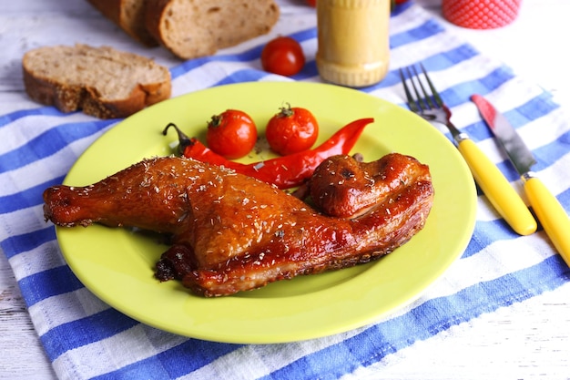 Perna de frango defumado com legumes no prato na mesa close-up