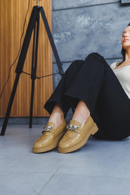 Pernas da mulher em calças e sapatos de couro bege